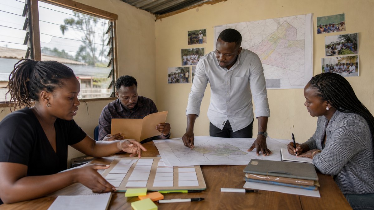 Independent Kenyan candidate and campaign team reviewing a constituency field plan with Vota